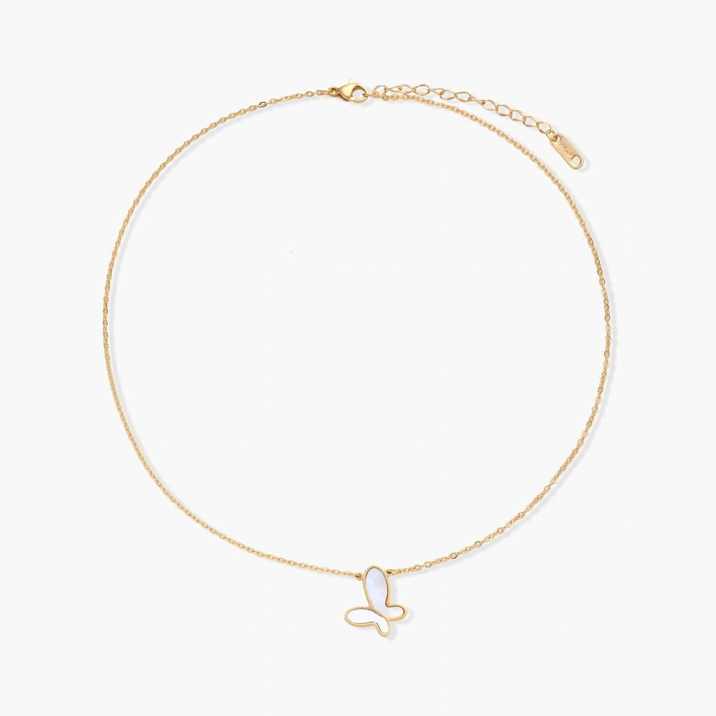 Gold-plated butterfly pendant with iridescent mother of pearl inlay on delicate chain against cream background.