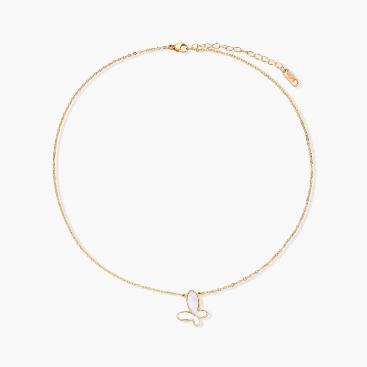 Gold-plated butterfly pendant with iridescent mother of pearl inlay on delicate chain against cream background.