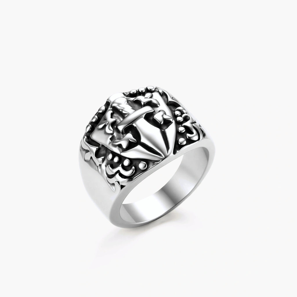 Silver 316L stainless steel men's signet ring with raised knight shield, cross motif, and ornate blackened scrollwork detailing.